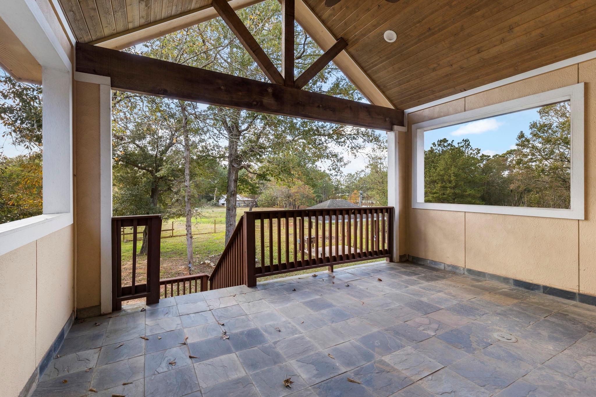 Upstairs patio features a gable ceiling and tongue and groove wood. - If you have additional questions regarding 1155 Whipporwill Road  in Conroe or would like to tour the property with us call 800-660-1022 and reference MLS# 12122183.