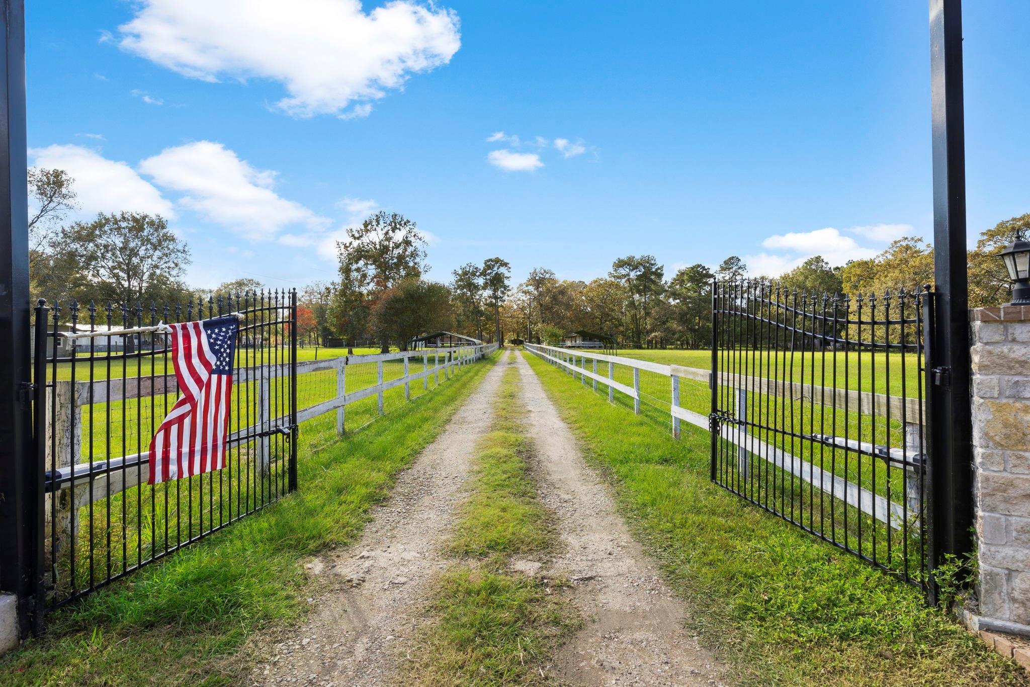 Automatic Entry Gate with grazing pastures on both sides - If you have additional questions regarding 1155 Whipporwill Road  in Conroe or would like to tour the property with us call 800-660-1022 and reference MLS# 12122183.