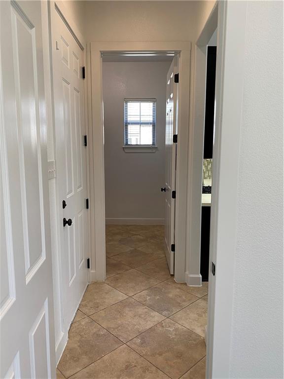 Hallway off kitchen with access to back patio, laundry room and primary bedroom suite - If you have additional questions regarding 710 W Lockhart Street  in Kyle or would like to tour the property with us call 800-660-1022 and reference MLS# 5441365.