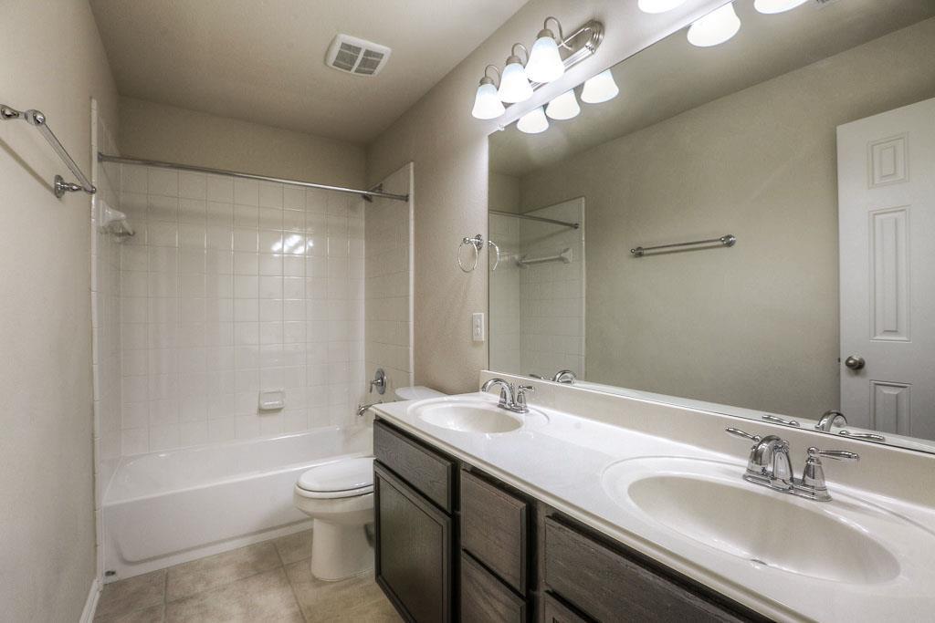 A large bathroom with two sinks on the first floor. - If you have additional questions regarding 8206 Laughing Falcon Trail  in Conroe or would like to tour the property with us call 800-660-1022 and reference MLS# 26206209.
