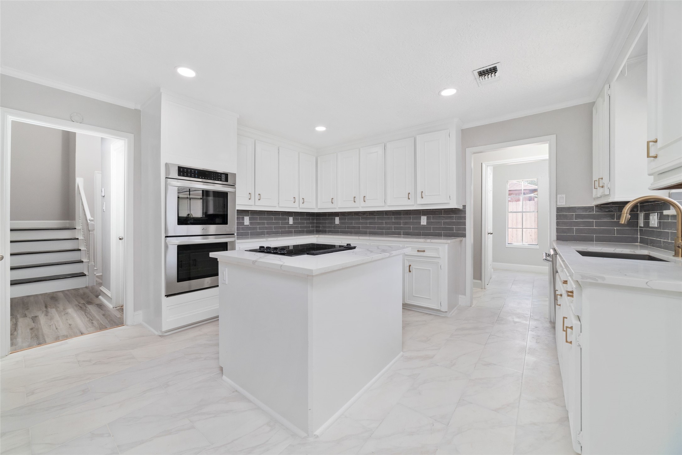 Kitchen with quartz counters, brass fixtures, and double ovens - If you have additional questions regarding 22506 Wetherburn Lane  in Katy or would like to tour the property with us call 800-660-1022 and reference MLS# 96980135.