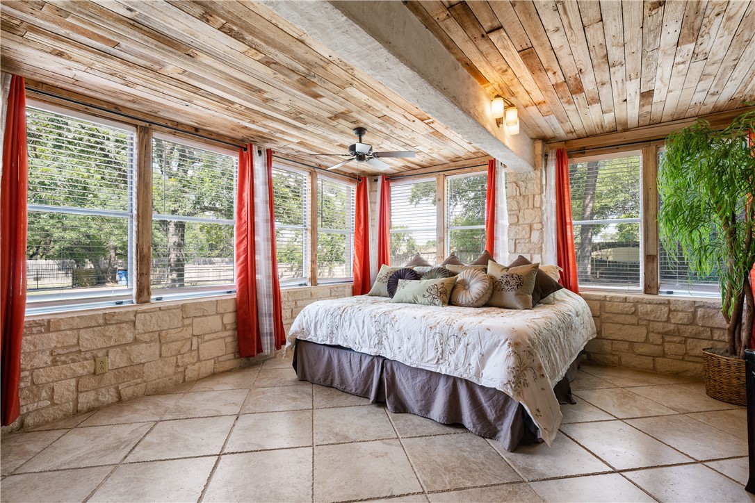 Owner's suite has stone walls, weathered wood ceilings, stone/tile floors and walls of windows with lakeview's from bedroom . - If you have additional questions regarding 16301 E Lake Shore Drive  in Austin or would like to tour the property with us call 800-660-1022 and reference MLS# 7548762.