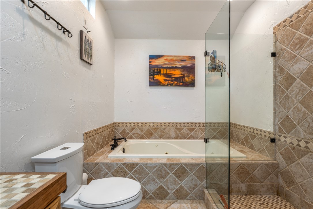 Main house bath has seamless glass walk in shower, jacuzzi bathtub with tile surround with designer accents. - If you have additional questions regarding 16301 E Lake Shore Drive  in Austin or would like to tour the property with us call 800-660-1022 and reference MLS# 7548762.