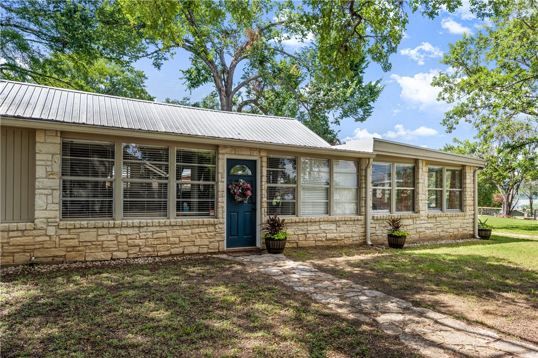 Side entryway to main house.  An abundance of windows let in natural light through the home. - If you have additional questions regarding 16301 E Lake Shore Drive  in Austin or would like to tour the property with us call 800-660-1022 and reference MLS# 7548762.