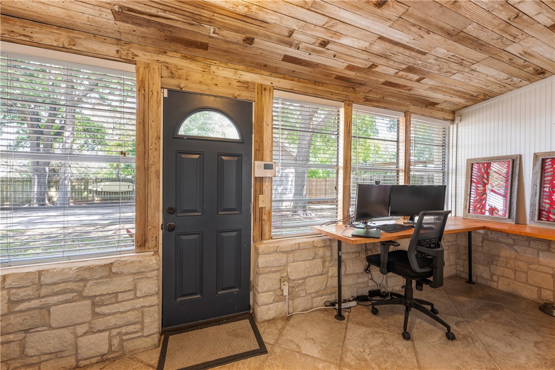 Entryway into main house is being used as an office.  Weathered wood ceilings & window trim with shiplap trim on wall. - If you have additional questions regarding 16301 E Lake Shore Drive  in Austin or would like to tour the property with us call 800-660-1022 and reference MLS# 7548762.