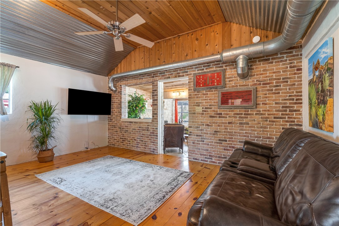 Living area has wood flooring, wood and metal ceilings, brick walls, high ceilings and opens to kitchen area. - If you have additional questions regarding 16301 E Lake Shore Drive  in Austin or would like to tour the property with us call 800-660-1022 and reference MLS# 7548762.