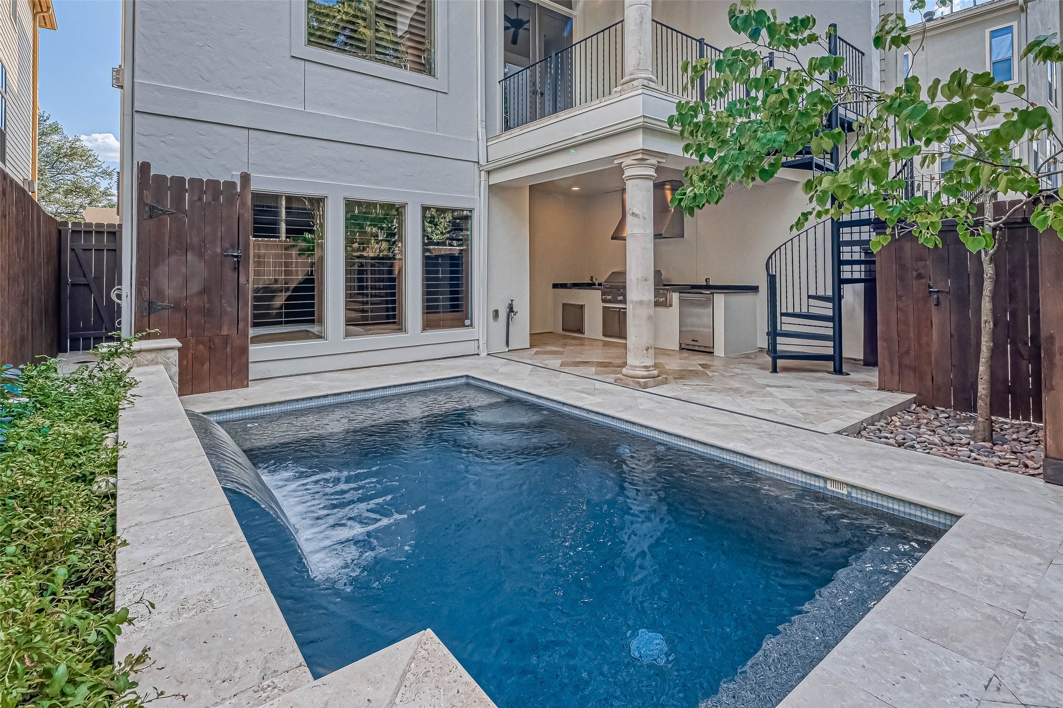 Backyard oasis with a pool and waterfall, outdoor kitchen and stairs leading to a covered patio on the 2nd floor - If you have additional questions regarding 6606 Rodrigo Street  in Houston or would like to tour the property with us call 800-660-1022 and reference MLS# 74006082.