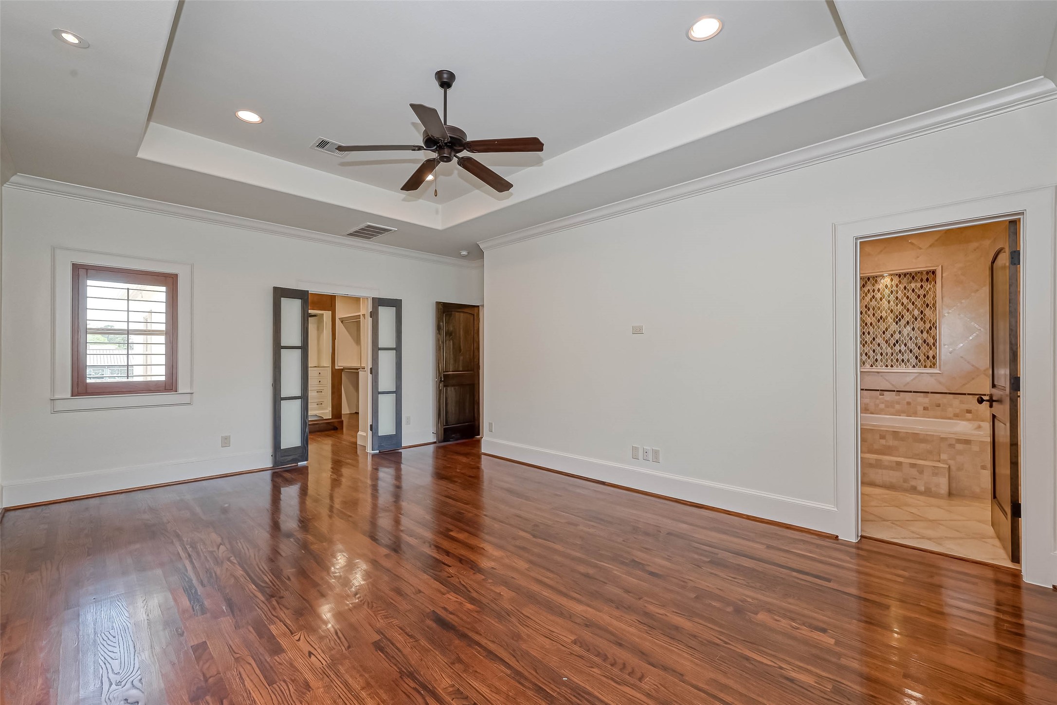 Primary bedroom with frosted double doors leading to a large walk in closet - If you have additional questions regarding 6606 Rodrigo Street  in Houston or would like to tour the property with us call 800-660-1022 and reference MLS# 74006082.