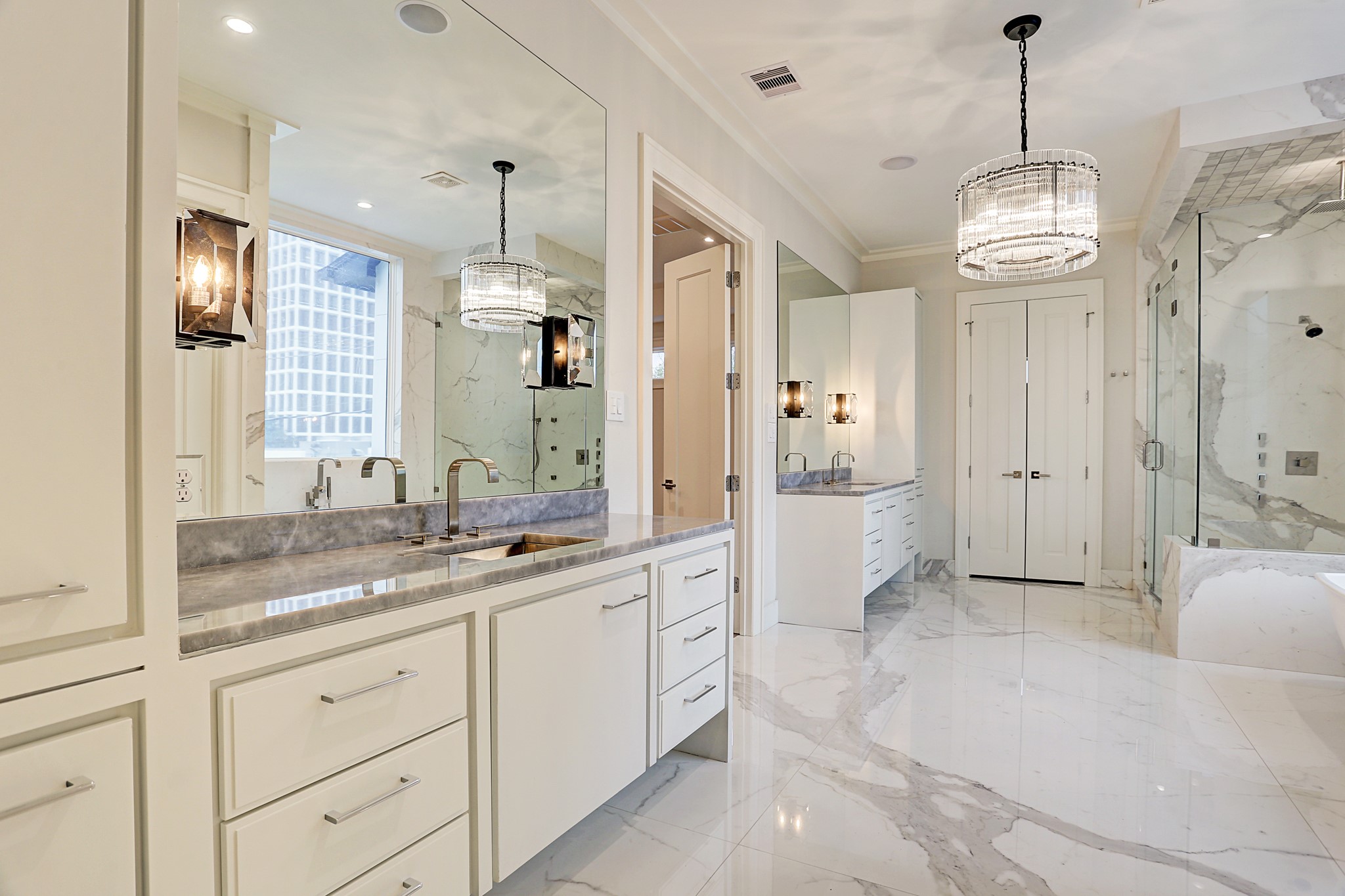 This alternate view of the primary bath highlights the dual vanities with imported vanity tops and undermount sinks as well as the Restoration Hardware lighting package. - If you have additional questions regarding 2514 Avalon Place  in Houston or would like to tour the property with us call 800-660-1022 and reference MLS# 13685198.