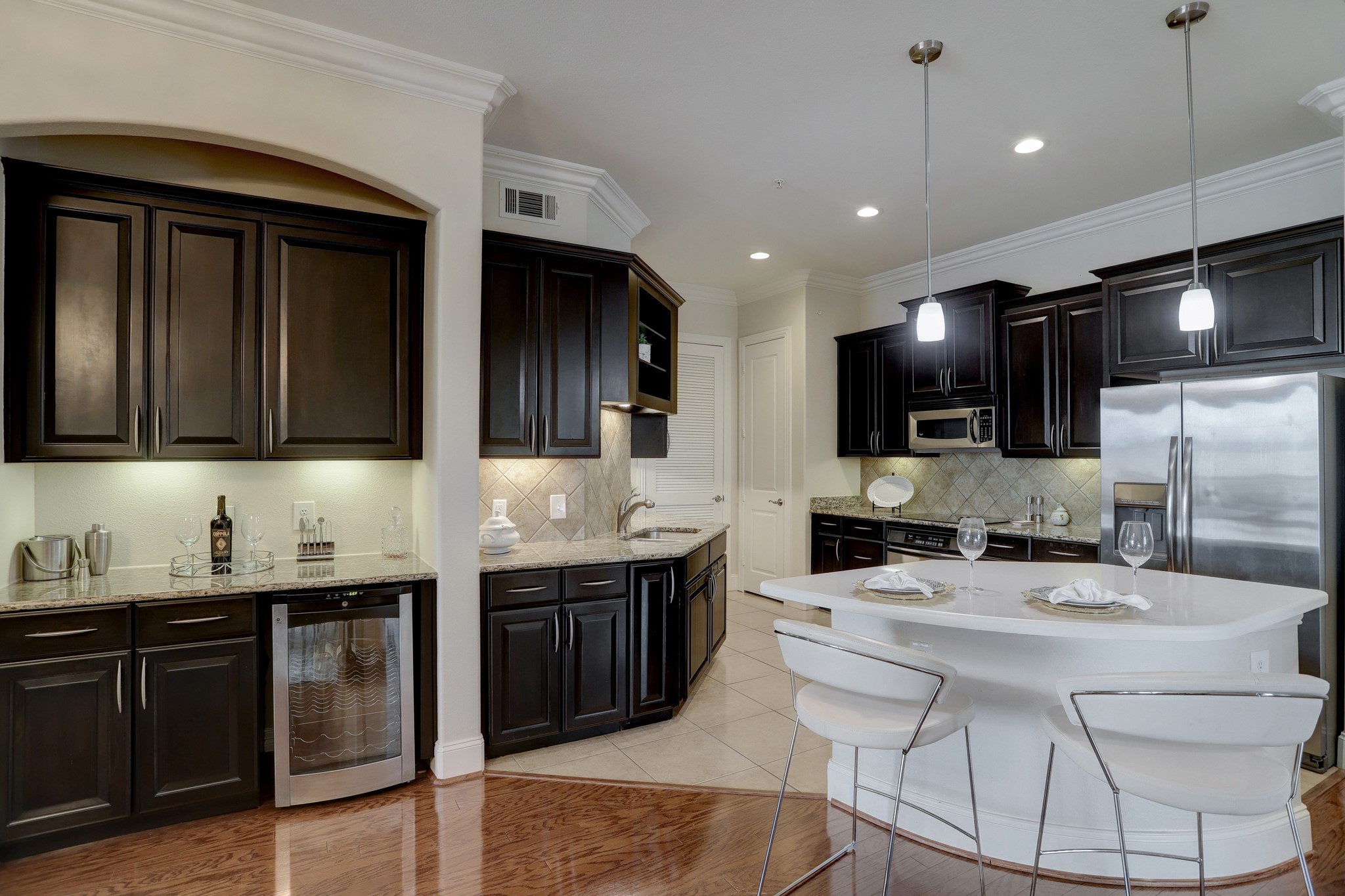 A buffet counter/bar area with a wine refrigerator makes hosting large gatherings effortless. - If you have additional questions regarding 2120 Kipling Street  in Houston or would like to tour the property with us call 800-660-1022 and reference MLS# 20665105.