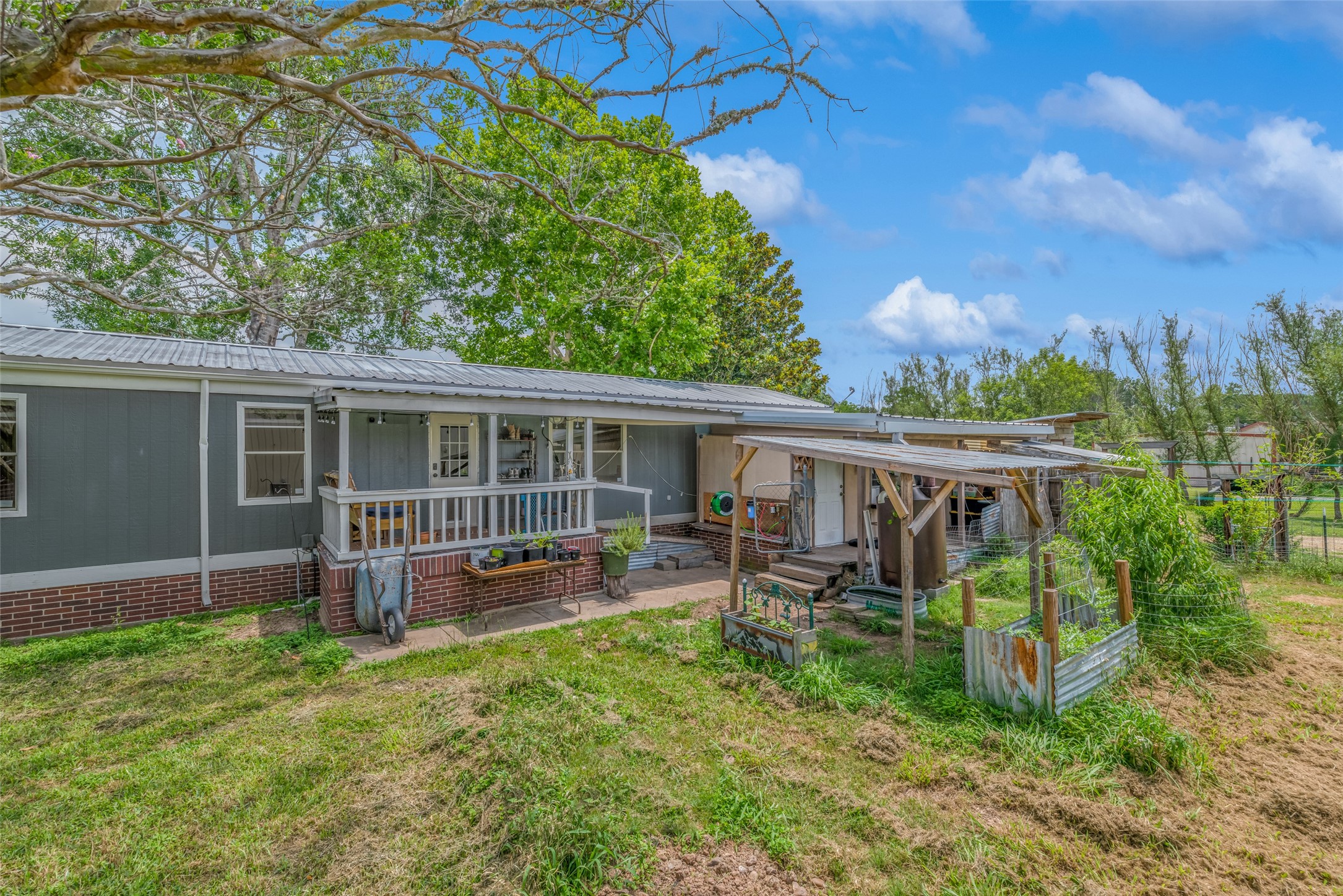 REAR OF MOBILE HOME FROM BACK YARD - If you have additional questions regarding 2055 Green Meadows Drive  in Sealy or would like to tour the property with us call 800-660-1022 and reference MLS# 16848431.