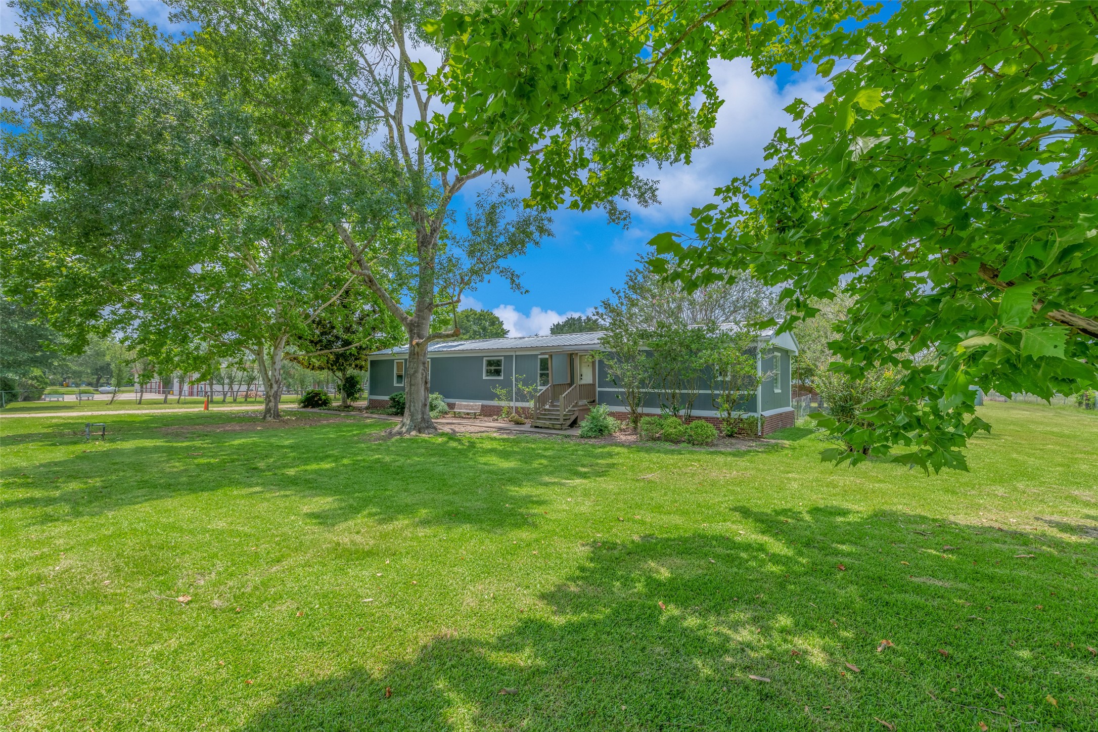 MOBILE HOME FROM RIGHT SIDE OF PROPERTY - If you have additional questions regarding 2055 Green Meadows Drive  in Sealy or would like to tour the property with us call 800-660-1022 and reference MLS# 16848431.