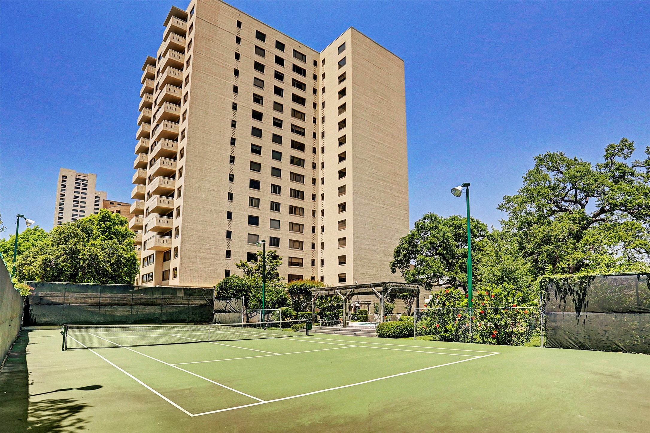 View of the East side of the building with full lighted tennis courts - If you have additional questions regarding 1400 Hermann Drive  in Houston or would like to tour the property with us call 800-660-1022 and reference MLS# 12717209.