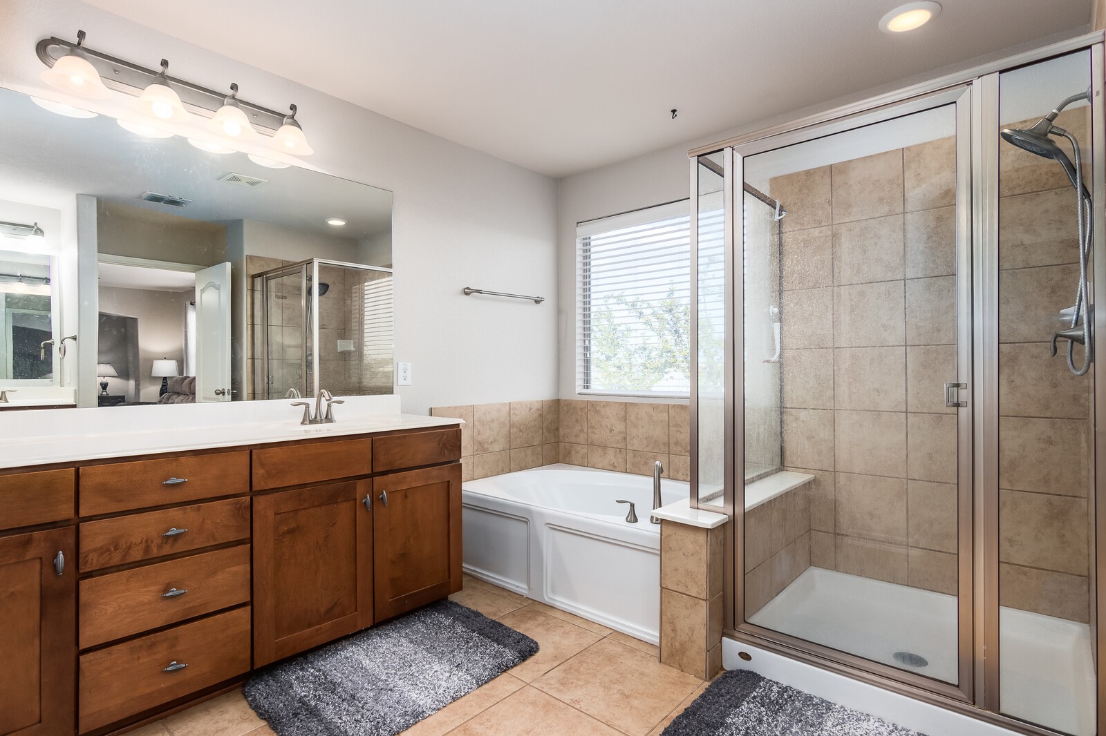 Primary bathroom with double vanities, stand-alone shower and a tub. - If you have additional questions regarding 23510 Woodlawn Ridge  in San Antonio or would like to tour the property with us call 800-660-1022 and reference MLS# 19662027.