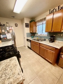 KITCHEN VIEW WITH REMODELED COUNTER TOPS AND GLASS BACKSPLASH - If you have additional questions regarding 11703 Hidden Quail Drive  in Austin or would like to tour the property with us call 800-660-1022 and reference MLS# 8681709.
