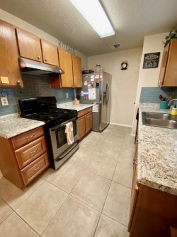 SECOND VIEW OF KITCHEN, TILE FLOORING, REMODELED BACK SPLASH AND COUNTER TOPS. - If you have additional questions regarding 11703 Hidden Quail Drive  in Austin or would like to tour the property with us call 800-660-1022 and reference MLS# 8681709.