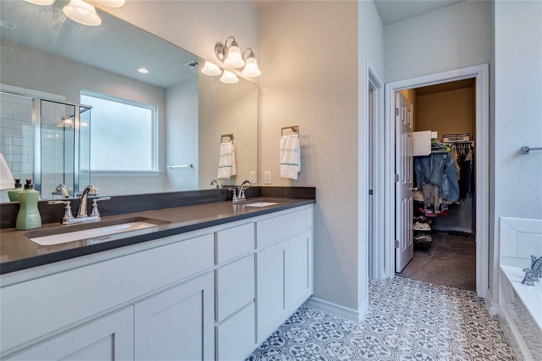 Owner's Suite bath features double vanity, quartz counters, and beautiful tile floors! - If you have additional questions regarding 3208 Bratton Crest Lane  in Austin or would like to tour the property with us call 800-660-1022 and reference MLS# 5470643.